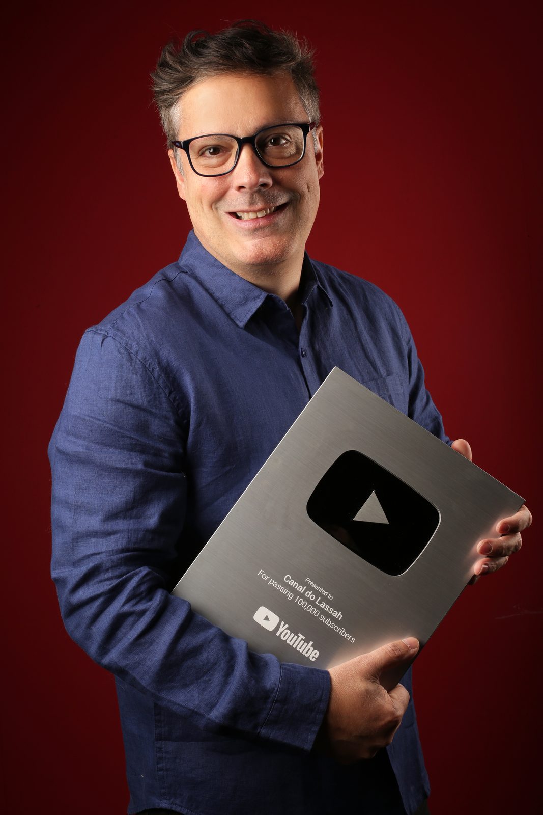 Eduardo Lassah, ator e criador de conteúdo no Rio de Janeiro Eduardo Lassah, ator, segurando a placa de 100 mil inscritos do YouTube